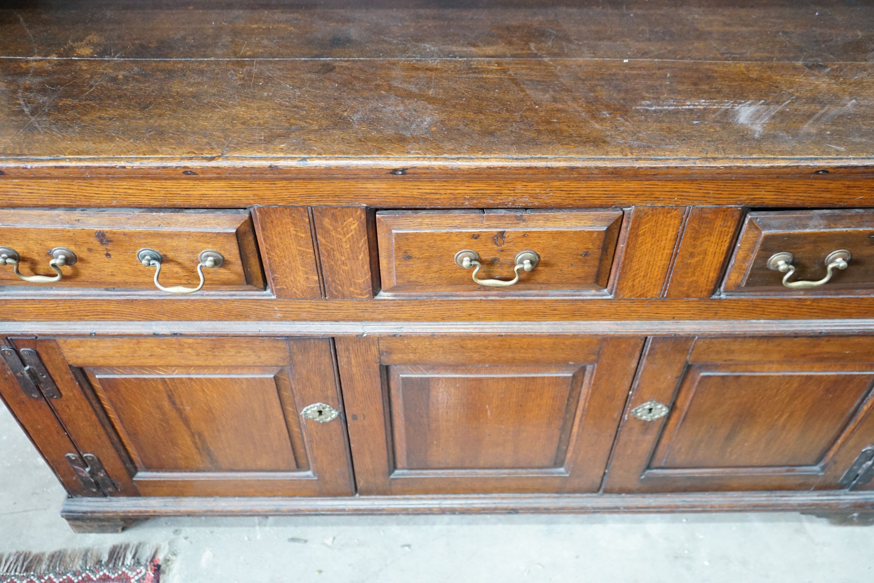 An 18th century oak dresser with boarded rack, width 150cm, depth 47cm, height 196cm